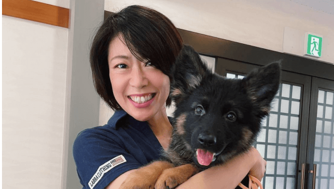 犬を抱き抱える笑顔の女性